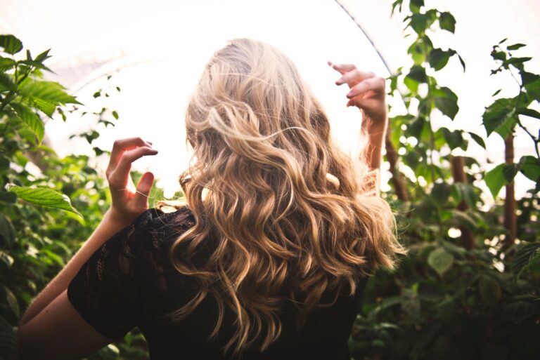 Femme séchant ses boucles avec un diffuseur devant un miroir