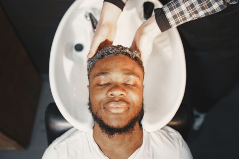 Personne lavant soigneusement ses cheveux bouclés sous la douche